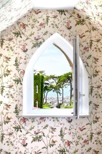 a window in a room with floral wallpaper at Domaine Saint Clair - Le Donjon in Étretat
