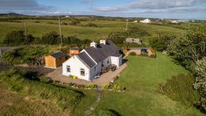 an aerial view of a white house in a field at Yellow Cottage, Doolin in Knockfin Cross Roads