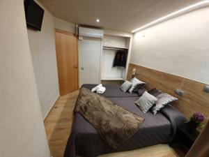 Un dormitorio con una cama grande con almohadas. en Pensión San Ramón en Barcelona