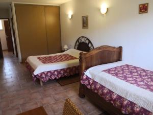 Ucciani的住宿－勒格利亞斯特魯住宿加早餐旅館，一间客房内配有两张床的房间