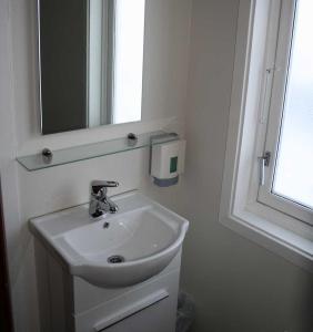 a bathroom with a sink and a mirror and a window at Offersøy Feriesenter in Offersøy