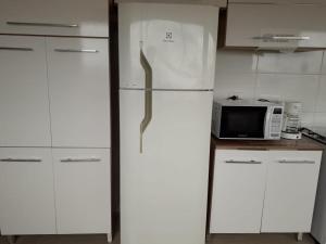 a white refrigerator in a kitchen with a microwave at Casa do Henrique 1 in Sorocaba