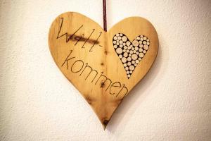een houten hart hangend aan een muur met de woorden gelukkige harmonie bij Haus Staud in Schmirn