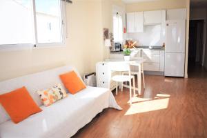 ein Wohnzimmer mit einem weißen Sofa und einer Küche in der Unterkunft Playa Pau Pi Eivissa AP945 in Oliva
