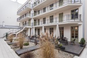 a large white building with tables and umbrellas at Krupnicza Apartment - 5 minut from Main Square by INPOINT CRACOW in Krakow