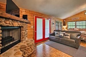uma sala de estar com um sofá e uma lareira em Riverfront Cabin with Fire Pit - 5 Mi to Pigeon Forge em Sevierville