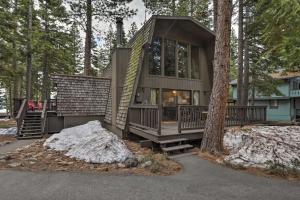 a small house in the woods with a tree at Near Skiing and Hiking Carnelian Bay Cabin in Carnelian Bay