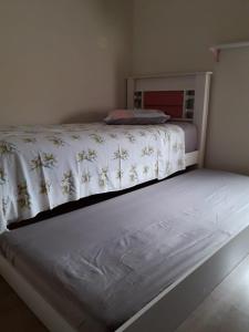 a bedroom with a bed with a white bedspread on it at Casa do Henrique 3 in Sorocaba