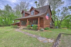 a wooden house with an american flag on it at Updated Cabin on White River by Boat Landing! in Calico Rock