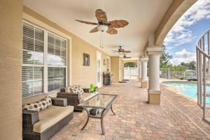 a patio with a couch and a table and a pool at Luxury Palm Coast Home with Dock and Game Room! in Palm Coast