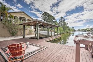 a wooden dock with a boat on a river at Luxury Palm Coast Home with Dock and Game Room! in Palm Coast