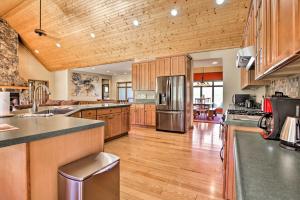 a large kitchen with wooden cabinets and stainless steel appliances at House with Deck, Fire Pit - 15 Mins to Snowshoe! in Slaty Fork