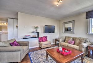 a living room with two couches and a table at Waterfront Condo on Pier in Downtown Astoria! in Astoria, Oregon