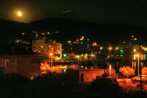eine nachts beleuchtete Stadt mit Straßenbeleuchtung in der Unterkunft Apartment Maslina in Vinišće