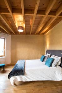 een slaapkamer met een groot bed met blauwe kussens bij B&B Wood Cottage in Étretat