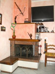 sala de estar con chimenea y TV de pantalla plana en Affittacamere Casa Sofia, en Anghiari