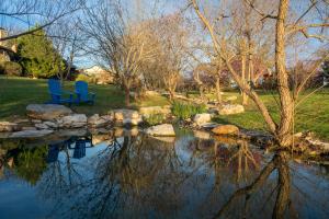 弗雷德里克斯堡的住宿－Barons CreekSide Resort，两个蓝色椅子坐在池塘旁