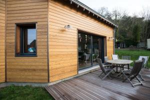 a wooden deck with a table and chairs on it at B&B Wood Cottage in Étretat