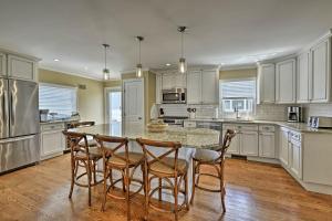 a kitchen with white cabinets and a table and chairs at Lavallette House with Fenced Yard and Gas Grill! in Lavallette