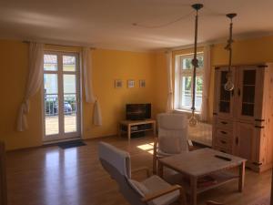 sala de estar con paredes amarillas, mesa y sillas en Ferienhaus Schwalbe Seebad Lubmin, en Lubmin
