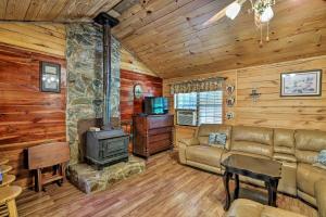 a living room with a couch and a stove at Secluded Cabin with Pond - 37 Mi to Gulf Coast! in Wiggins