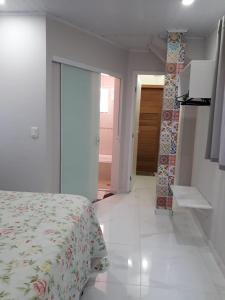 a bedroom with a bed and a hallway with a door at Casa do Henrique 2 in Sorocaba