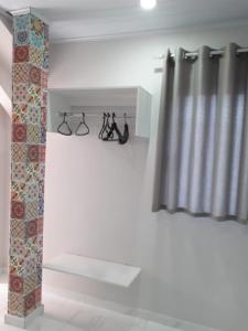 a room with a curtain and a shelf with shoes at Casa do Henrique 2 in Sorocaba