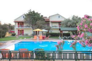 a large swimming pool with chairs and a building at Aria in Lakíthra