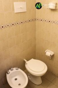 
a white toilet sitting in a bathroom next to a sink at Hotel Alto Parana in Córdoba
