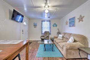 a living room with a couch and a table at Gulfport Home with Deck and Grill, Walk to Beach! in Gulfport