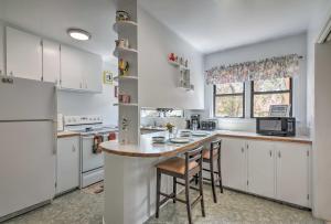 a kitchen with white cabinets and a counter with stools at Panguitch Home with Patio about 24 Mi to Bryce Canyon in Panguitch