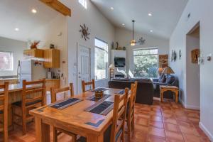 uma cozinha e sala de estar com uma mesa de madeira e cadeiras em Rim Village Two-Bedroom em Moab