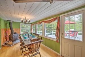 een eetkamer met een tafel en een houtkachel bij Charming Wilmington Cabin, 8 Mi to Mt Snow! in Wilmington