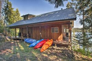 a small cabin with four kayaks in front of it at South Lake Coeur dAlene Home with Dock and Kayaks! in Worley