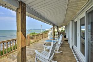 a porch with white chairs and a view of the ocean at Waterfront Harkers Island Home Sunset View and Dock in Harkers Island