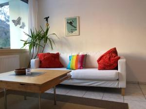 sala de estar con sofá blanco y almohadas coloridas en Ferienwohnung Held, en Obertraun