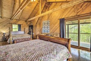 a bedroom with two beds in a log cabin at Spacious Cabin on Dale Hollow Lake with Hot Tub! in Albany