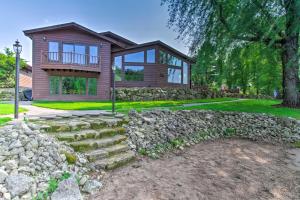 a home with a stone retaining wall and a stone fence at Lakefront Eau Galle Home with Hot Tub and Fire Pit in Durand