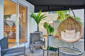 a porch with a swing and two chairs and a table at RA suites in Pompano Beach