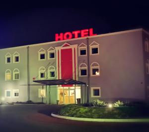 a hotel with a red sign on the side of it at Hotel Holidays in Słubice