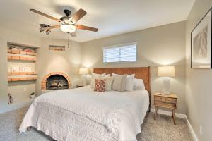 a bedroom with a bed with a ceiling fan and a fireplace at Red Rock Views Modern Sedona Home in Sedona