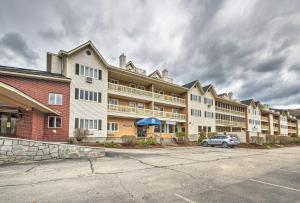 a large apartment building with a car parked in a parking lot at Lincoln Resort Condo with Pool Access - Near Hiking! in Lincoln