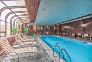 a swimming pool with lounge chairs next to a building at Lincoln Resort Condo with Pool Access - Near Hiking! in Lincoln