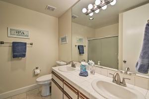 a bathroom with two sinks and a toilet and a mirror at Cathedral City Condo on Golf Course with Patio! in Cathedral City +16 photos