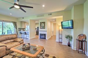 a living room with a couch and a flat screen tv at Cathedral City Resort Condo on a Golf Course! in Cathedral City