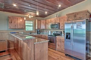 uma cozinha com armários de madeira e um frigorífico de aço inoxidável em Guntersville Cabin with Views - Hike to Lake! em Guntersville