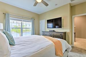 a bedroom with a large bed and a flat screen tv at Kissimmee Retreat with Pool, about 6 Mi to Disney in Kissimmee