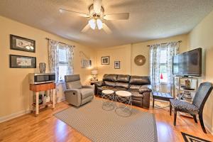 a living room with leather furniture and a flat screen tv at Nags Head Apt with Patio - half Mile Walk to Beach! in Nags Head