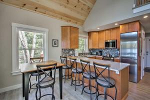 a kitchen with a island with bar stools at Lakefront Meredith Home Private Beach and Fire Pit! in Meredith