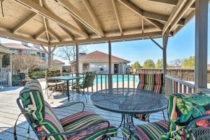 a patio with a table and chairs and a pool at Waterfront Hot Springs Condo with Pool Access! in Hot Springs